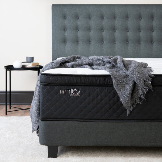 Hamuq Original Hybrid mattress with a grey throw in a bedroom